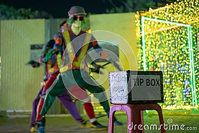 Selective focus on tip box in front of the dancing performance on the public street. Thai language means Thank you for support Editorial Stock Photo