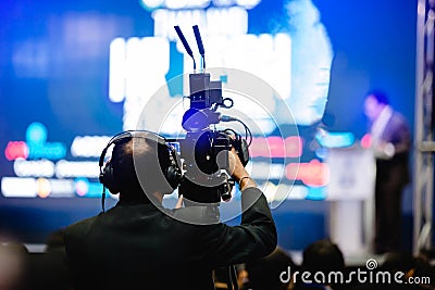 Selective focus to cameraman and video camera set are recording to speaker and audience in conference hall or seminar event Editorial Stock Photo