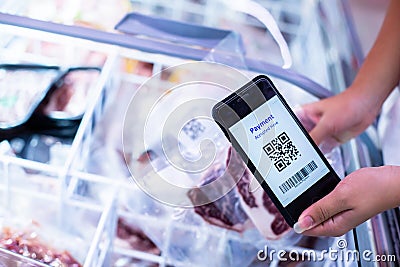 Selective focus to QR code tag on smartphone with blurry frozen food at supermarket Stock Photo