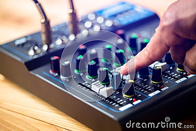 Selective focus to sound electronics mixer and equalizer with hand to turning and adjusting button and slide volume Stock Photo