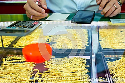 Selective focus to staff hand will writing sale order of gold jewelry in the gold shop Stock Photo