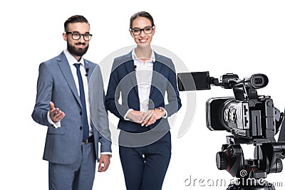 selective focus of two newscasters taking and looking at camera, Stock Photo