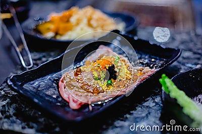 Selective focust to set of grilled Wagyu beef sushi with fish roe and Tobiko on black plate in Japanese restaurant Stock Photo