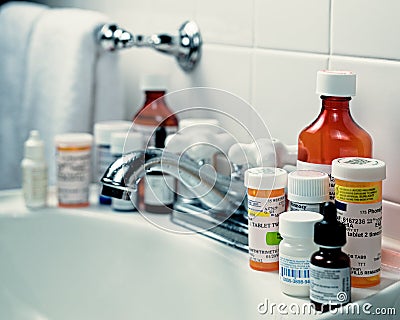 Prescription medicine bottles on bathroom sink overloaded with prescription medicines Editorial Stock Photo