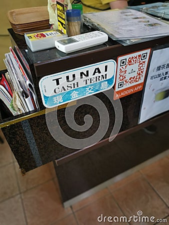 Self adhesive signboard of `Cash term` english language with mandarin and malay interpretation paste by the side counter table Editorial Stock Photo