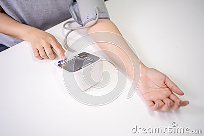 Self blood pressure and heart rate measurement with blood pressure monitor machine, with copy space Stock Photo