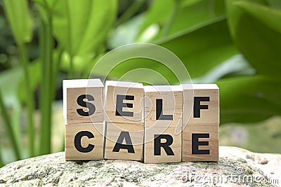 Self care word on wood cubes on green nature background Stock Photo