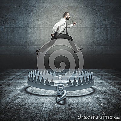 self-confident businessman jumps a big bear trap Stock Photo