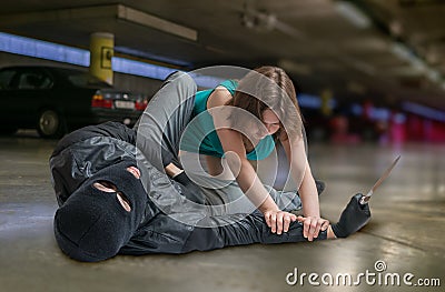 Self defense concept. Young woman is fighting with mugger or thief Stock Photo