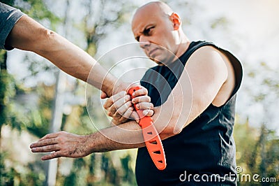 Self defense disarming technique against threat and knife attack Stock Photo