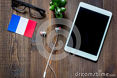 Self-development. Learning frensh online. Headphones and tablet PC on wooden background top view copyspace mockup Stock Photo