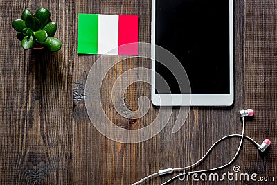 Self-development. Learning italian online. Headphones and tablet PC on wooden background top view copyspace mockup Stock Photo