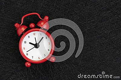 Self discipline, time, deadline and meeting schedule background with cute red alarm clock on dark black background with texture Stock Photo