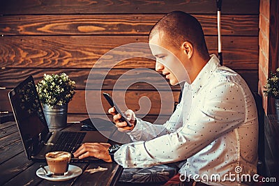 Self employed happy man working with a laptop and a smart phone Stock Photo