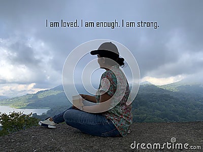 Self healing with affirmation words - I am loved. I am enough. I am strong. With an adventure woman sitting alone holding a cup of Stock Photo