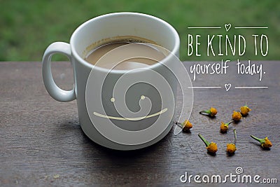 Self Inspirational motivational quote - Be kind to yourself. With smiling mug of white coffee on wooden table and little flowers Stock Photo