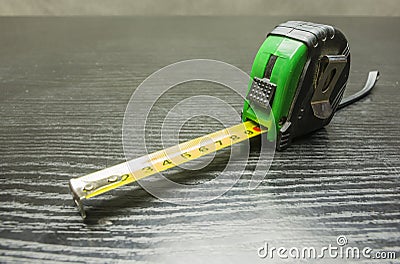 Self-retracting metal tape measure on the table. Stock Photo