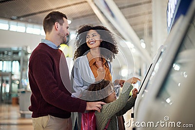 Self service, travel and interracial with family in airport for check in, vacation and global. Technology, digital and Stock Photo