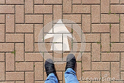 Selfie of feet and arrows on the road. top view. Businessmen in black shoes standing on a road with many white arrow pathway sign Stock Photo