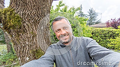 Selfie handsome middle aged man on home garden park cheerful guy making a photo Stock Photo