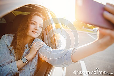 Selfie photo of beautiful girl driving car sunset. Concept driver travel Stock Photo