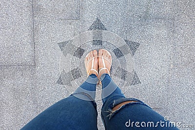 Selfie Shoes with Direction Arrows Choices. Woman Feet and Sandal Standing on Concrete Road Background Stock Photo