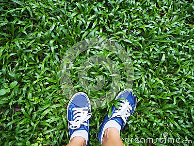 Selfie woman feet wearing blue sneaker on green grass Stock Photo