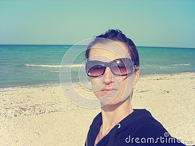 Selfie of a young woman on the beach; faded, retro style Stock Photo