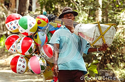 The seller of children`s toys balloons peddles his merchandise in the village of Ngebel Editorial Stock Photo