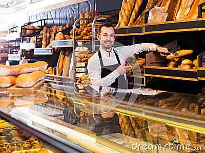 Seller offering fresh loaf of bread Stock Photo
