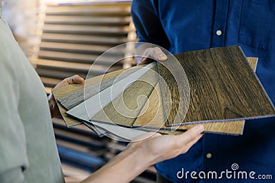 Seller showing wooden texture laminate material samples to customer Stock Photo