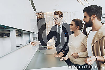 The seller shows a young couple the kitchen. Stock Photo