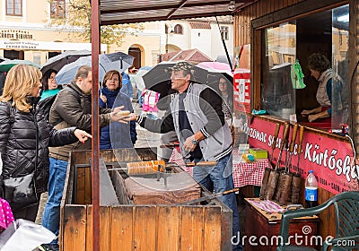 The seller in the Small Square cooks and sells sweets to tourists in Sibiu city in Romania Editorial Stock Photo