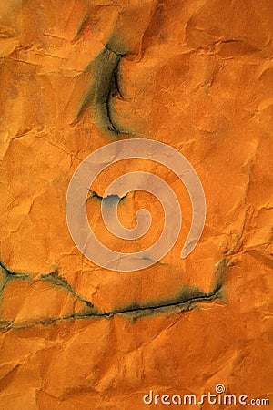 Semi burned orange paper as background Stock Photo