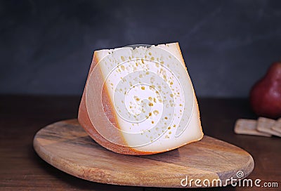 Semi-solid milk cheese on a wooden board with crackerc and pear Stock Photo