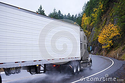 Semi truck and reefer trailer wheels in autumn rain dust Stock Photo