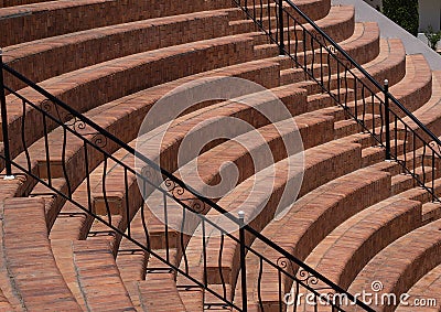 Semicircular steps in the amphitheater sector with black metal railings, a fragment of the seats - steps Stock Photo