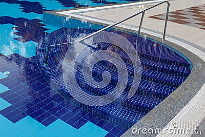 Semicircular steps of blue colour in the large pool with clear water Stock Photo
