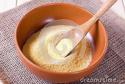 Semolina in a bowl with a wooden spatula Stock Photo