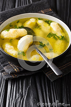 Semolina Dumpling Soup Griessnockerlsuppe very delicious are these dumplings in clear vegetable soup close-up in a plate. Vertical Stock Photo