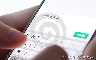 Sending I love you text message with mobile phone. Online dating, texting or catfishing concept. Romance fraud, scam. Stock Photo