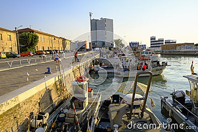 Senigallia, Italy: Boats in the port during sunrise. Senigallia marina across buildings. Canal in Senigallia Editorial Stock Photo