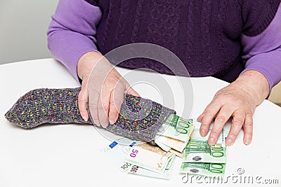 Senior adult with her savings in a sock Stock Photo