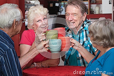 Senior Adults Toasting with Mugs Stock Photo