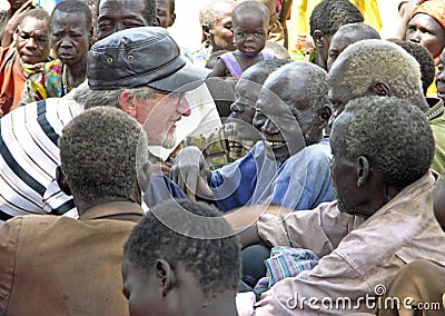 Senior aid relief volunteer smiling laughing with old African men Uganda, Africa Editorial Stock Photo