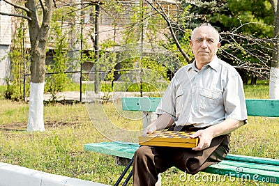 Senior amputee sitting on a park bench Stock Photo