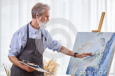 mature artist painting on easel, canvas Stock Photo