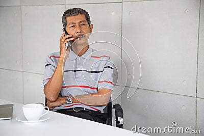 Senior Asia businessman sit and ose mobile phone Stock Photo