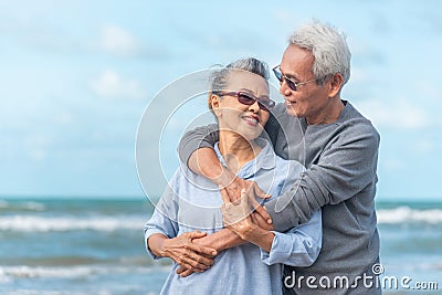 Senior asia couple relaxing by the sea on sunny day Stock Photo