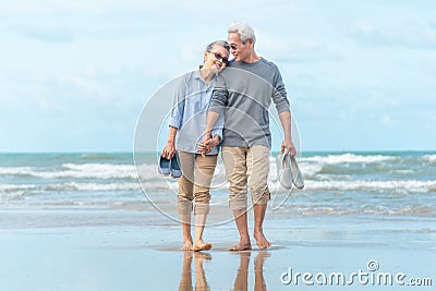 Senior asia Couple Running Along Winter Beach Stock Photo